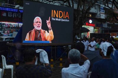 People watch the BBC documentary 'India: The Modi Question', on a screen installed at the Marine Drive junction in Kochi.  AFP