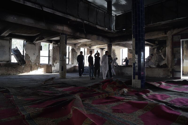Afghan men inspect the interior of a Shiite mosque a day after a suicide attack on the premises in Kabul on August 26, 2017. Shah Marai / AFP