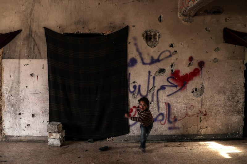 epa06404684 A girl runs inside an abandoned school in Hamoria, Eastern al-Ghouta, Syria, 23 December 2017 (Issued 24 December 2017). Abu Hassan, a 75 years old Syrian man, and the 105 members of his family (his children, grandchildren, and great grandchildren) live at an abandoned destroyed school at Hamoria in Eastern al-Ghouta, after being displaced mid 2016 from Hawsh al-Dawahira, an area at the outskirts of rebel-held Douma and is considered now to be on the frontline. The family uses plastic waste, rubbish, and thick cloth for cooking and baking, and they also sell nylon and other plastic wastes to people for similar usage.  EPA/MOHAMMED BADRA