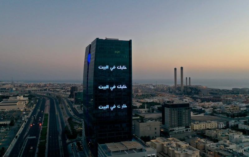 An aerial view shows deserted streets in the Saudi coastal city of Jeddah on April 21, 2020, as the message "stay home" in Arabic is displayed on a tower during the novel coronavirus pandemic crisis. / AFP / BANDAR ALDANDANI
