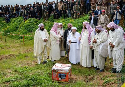 Iraqi Yazidi clerics attend the exhumation of a mass-grave of hundreds of Yazidis killed by Islamic State (IS) group militants in the northern Iraqi village of Kojo in Sinjar district on March 15, 2019. - Iraqi authorities exhumed the mass grave in an operation aiming to extract remains and identify victims of an August 2014 massacre of Yazidis by IS fighters as they entered the village of Kojo, during investigations of genocide against the decimated minority. (Photo by Zaid AL-OBEIDI / AFP)