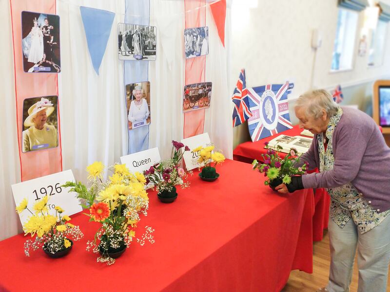 Residents of the Lawn care home in Alton, Hampshire,  decorate an area with photographs of Queen Elizabeth, bunting and their own flower arrangements. PA