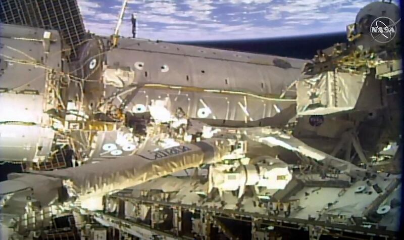 This NASA TV video frame grab shows Astronauts Mike Hopkins and Victor Glover, Jr.(C) as they finish a four-year effort to upgrade the International Space Station’s power system during a spacewalk on February 1, 2021. - Astronauts Mike Hopkins and Victor Glover are conducting a spacewalk Monday to finish battery upgrades and install high-definition cameras outside of the International Space Station. This is the second spacewalk for the duo in just a matter of days. (Photo by Handout / NASA TV / AFP) / RESTRICTED TO EDITORIAL USE - MANDATORY CREDIT "AFP PHOTO /NASA TV/HANDOUT " - NO MARKETING - NO ADVERTISING CAMPAIGNS - DISTRIBUTED AS A SERVICE TO CLIENTS