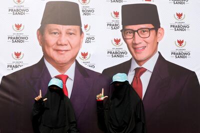 FILE PHOTO: Women wearing full-face veil gesture next to a banner of presidential candidates Prabowo Subianto, and his running mate Sandiaga Uno, as they attend a campaign rally in Bandung, West Java province, Indonesia, March 28, 2019. REUTERS/Willy Kurniawan/File Photo