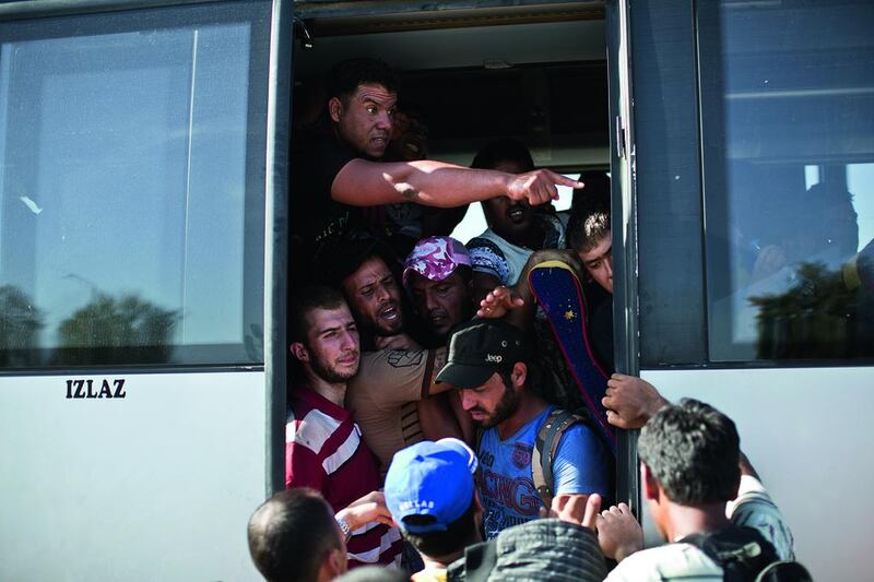 People crowd a bus provided by the Croatian government, after pushing through police lines in Tovarnik, Croatia in September. Hundreds of migrants have pushed through police lines in the eastern Croatian town of Tovarnik, with people trampling and falling on each other amid the chaos. Marko Drobnjakovic / AP