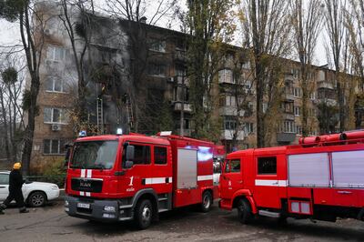 Firefighters work to put out a fire in a residential building in Kyiv hit by a Russian strike, on November 15.  Reuters