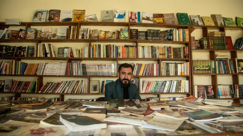 Kamiran Khalaf sitting in the middle of his newly opened bookstore in the city of Sinjar in northern Iraq. Haider Husseini for The National