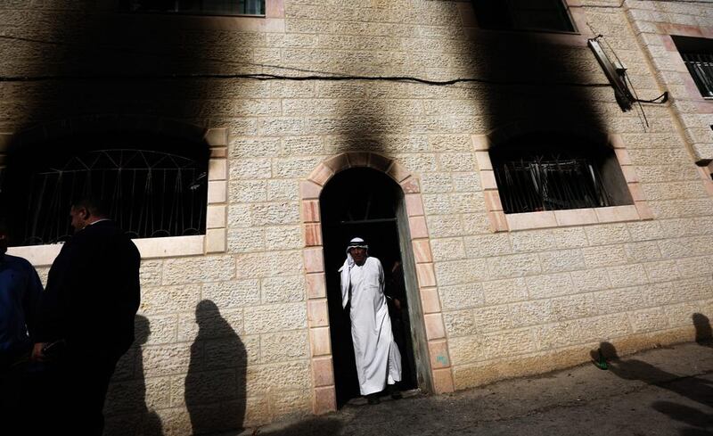 A Palestinian man stands in a doorway as he joins others in inspecting the damage at a mosque of the West Bank village of Al Mughayir after it was reportedly set on fire. Atef Safadi/EPA