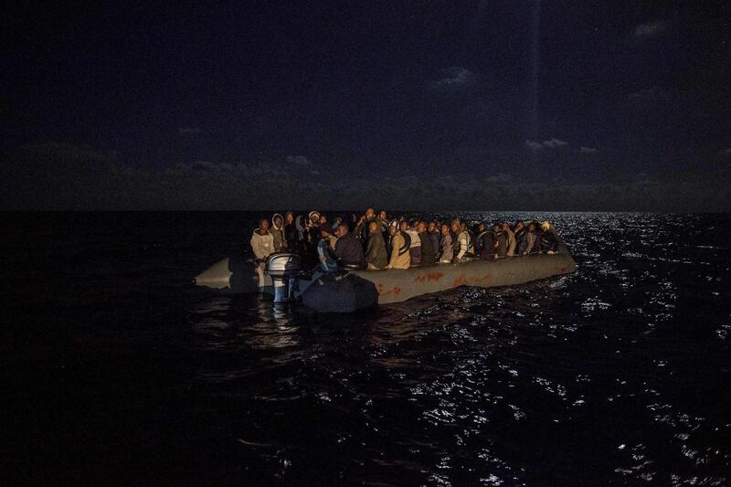 (FILES) In this file photo taken on December 22, 2018 migrants onboard an inflatible boat wait for being rescued off the coast of Libya by Proactiva Open Arms organisation. The Spanish government announced on August 15, 2019 that it is willing to welcome a portion of the migrants rescued in the Mediterranean by the ship of the Spanish NGO Open Arms, on condition that a distribution agreement between several European countries is reached. / AFP / Olmo CALVO
