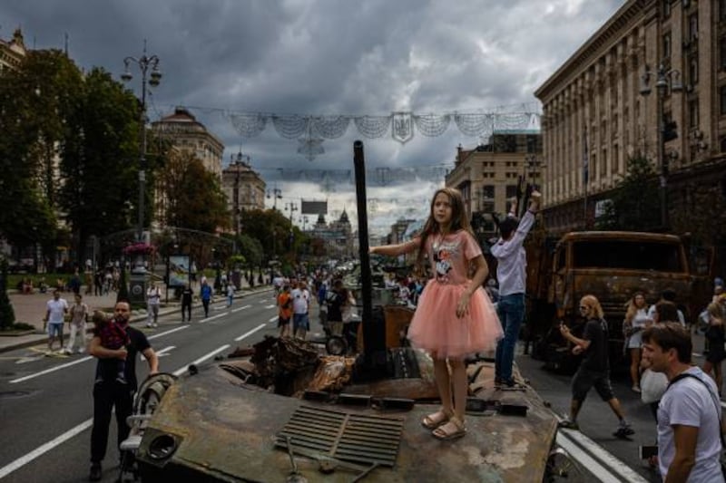 A girl stands on top of a destroyed Russian tank in Kyiv, on a street that has been turned into an open-air military museum before Ukraine's Independence Day on August 24. AFP