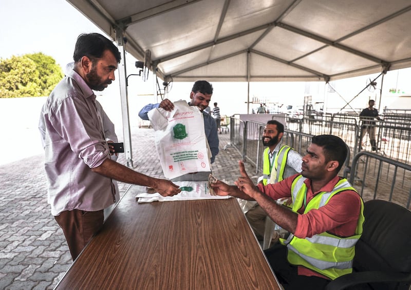 Abu Dhabi, U.A.E., August 22 , 2018.  Livestock shoppers for the second day of Eid Al Adha at the Abu Dhabi Livestock Market and the Abu Dhabi Public Slaughter House (Abu Dhabi Municipality) at the  Mina area.-- A customer pays the cashier before his livestock is processed at the slaughter house.
Victor Besa/The National
Section:  NA
For:  stand alone and stock images
