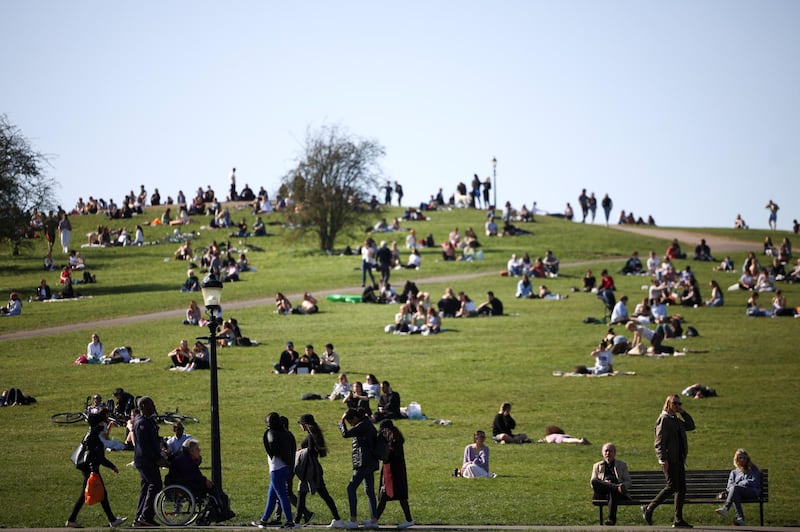 People relax in the warm weather on Primrose Hill, London. As Covid-19 restrictions are eased, sports facilities are reopening. Reuters