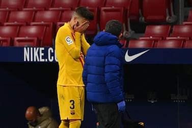 Barcelona's Spanish defender Gerard Pique (L) reacts as he walks off the pitch after getting injured during the Spanish League football match between Club Atletico de Madrid and FC Barcelona at the Wanda Metropolitano stadium in Madrid on November 21, 2020. / AFP / GABRIEL BOUYS