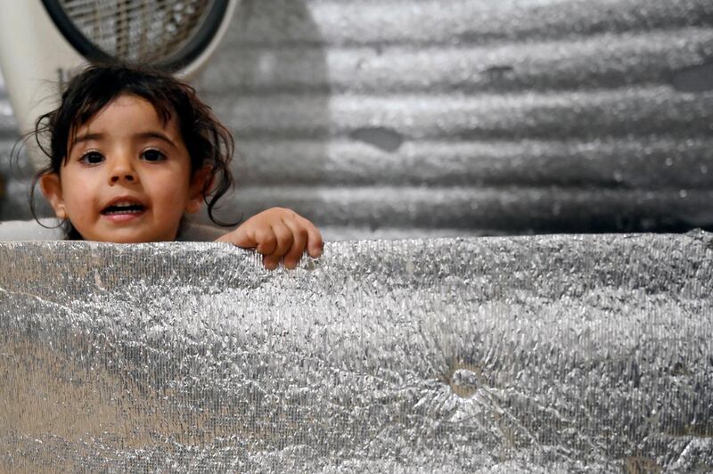 A Syrian girl who suffers from scoliosis sits inside a tent at a Syrian refugees camp in Akkar, Lebanon.  EPA