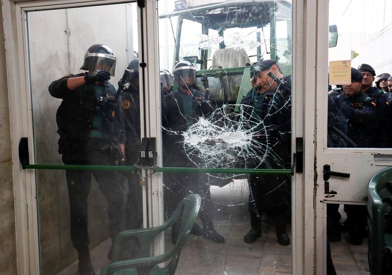 Spanish Civil Guard officers break through a door at a polling station for the banned independence referendum where Catalan President Carles Puigdemont was expected to vote. Juan Medina / Reuters