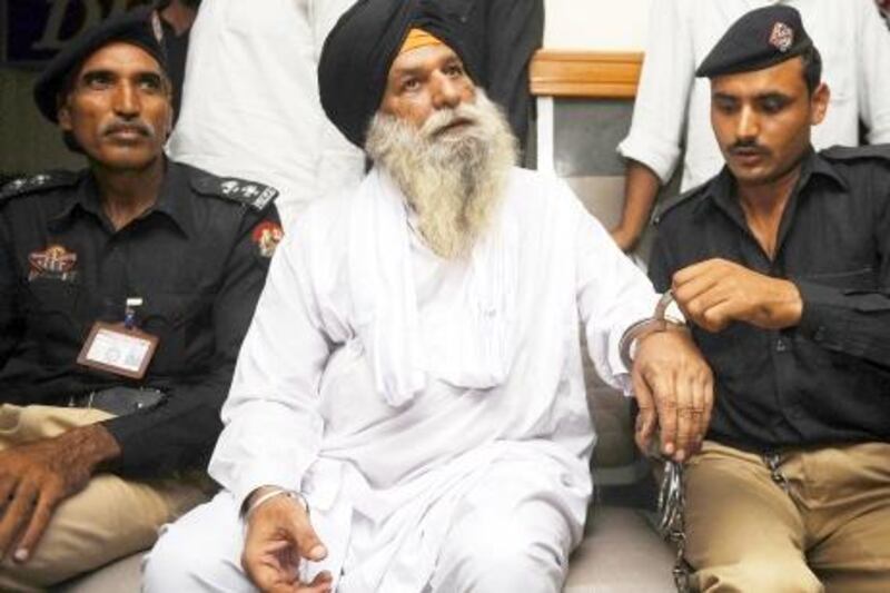 Released Indian prisoner Surjeet Singh, escorted by Pakistani security officials, sits at a waiting lounge before his departure from Pakistan to India at the Wagah border on June 28, 2012. An Indian man freed after spending three decades in a Pakistani prison for spying walked across the border Thursday into India where he was met by family and hordes of reporters. AFP PHOTO / ARIF ALI

 *** Local Caption ***  879963-01-08.jpg fo29ju-IndiaBriefs.jpg