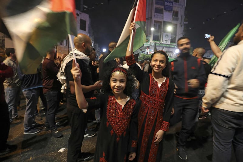 Palestinians celebrate in Ramallah after the announcement of a ceasefire between the Palestinians and Israel. AFP