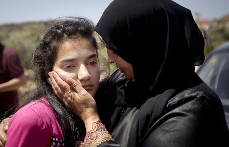 Sabha Al Wawi comforts her 12-year-old daughter, Dima, after her release from an Israeli prison,  near the West Bank town of Tulkarem. Majdi Mohammed / AP Photo