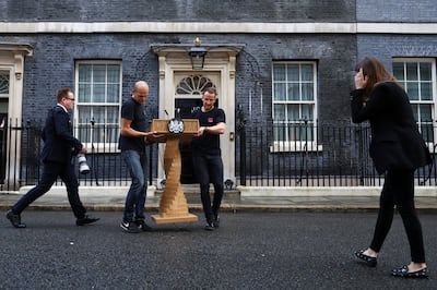 Staff place a podium in front of Number 10 Downing Street before Liz Truss delivers a speech on her last day in office. Reuters 