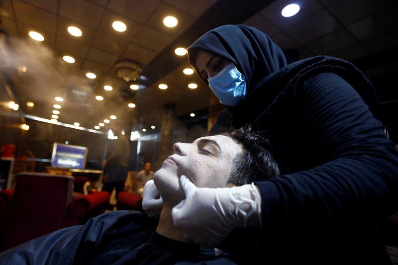 An Iraqi hairdresser cleans the face of a customer at a men's barber shop in the city of Hilla, Iraq. Reuters