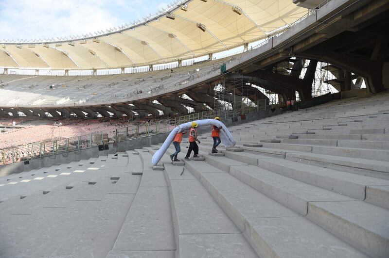 Workers at the construction site of the world's largest cricket stadium in Motera. AFP