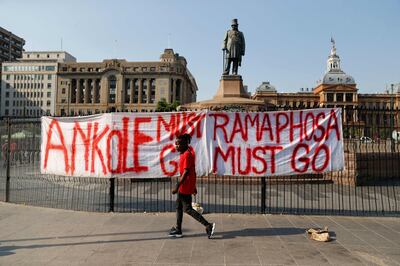 A member of the the Economic Freedom Fighters (EFF) walks past a banner that reads "Ramaphosa must go" at Church Square in Pretoria on March 20, 2023 during a "national shut-down" called by their party.  (Photo by PHILL MAGAKOE  /  AFP)