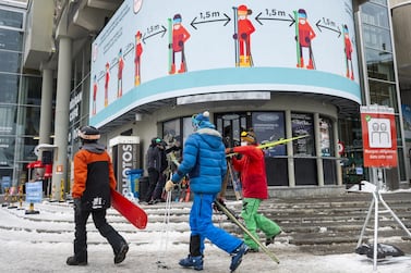 eSkiers pass a sign in the ski resort of Verbier informing about social distancing for skiers at the departure of the Medran gondola lifts in Verbier, Switzerland. EPA