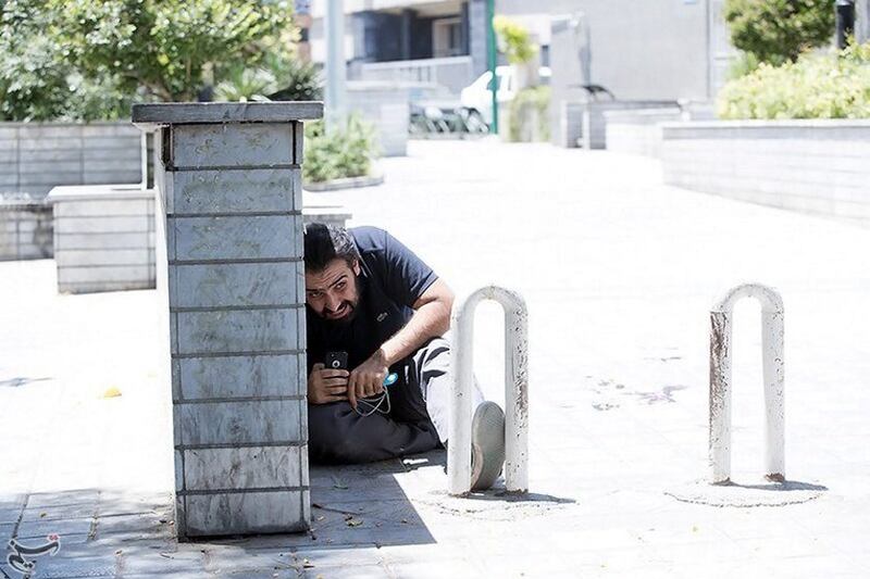 A man takes cover during an attack on the Iranian parliament in central Tehran, Iran. Tasnim News Agency / Handout via Reuters