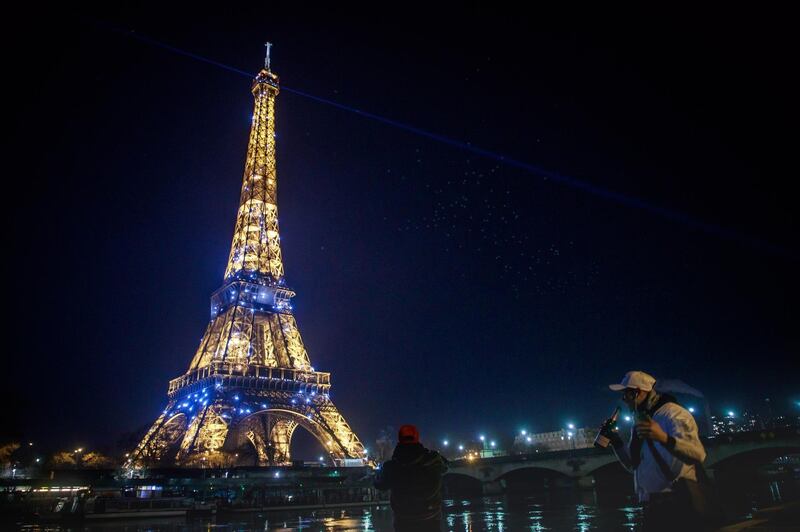 People drink champagne on the banks of the Seine. EPA