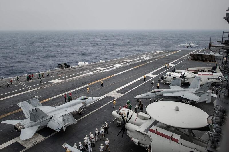 A US Navy Boeing F/A-18 Super Hornet fighter jet (background) takes off and other F/A-18s, an E-2C Hawkeye airborne early warning aircraft (bottom right), and a C-2A Greyhound transport aircraft (top right) on the flight deck of the aircraft carrier USS George Washington. Canada plans to order 18 Super Hornets. Philippe Lopez / AFP