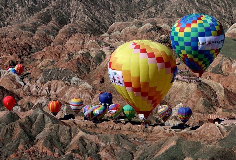 Hot air balloons fly over Qicai Danxia scenic area during a festival in Zhangye, China. Reuters