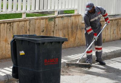 A migrant worker from Bangladesh, who works for waste management company RAMCO, sweeps a street in Jdeideh, near Beirut, Lebanon, May 19, 2020. Picture taken May 19, 2020. REUTERS/Mohamed Azakir