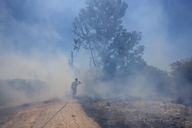 An Israeli firefighter attempts to extinguish a fire caused by an incendiary balloon on Tuesday. AP