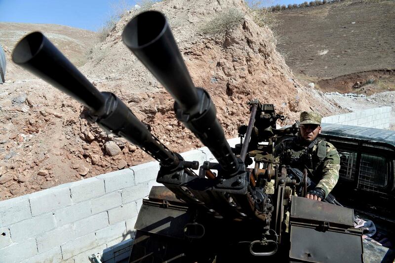 In this Sunday, Sept. 9, 2018 photo, fighters with the Free Syrian army patrol the outskirts of the northern town of Jisr al-Shughur, Syria, west of the city of Idlib. In the northern Idlib province, a corner of nearly 3 million people, Syria's government and its opponents are preparing for a final, bloody showdown. (Ugur Can/DHA via AP)