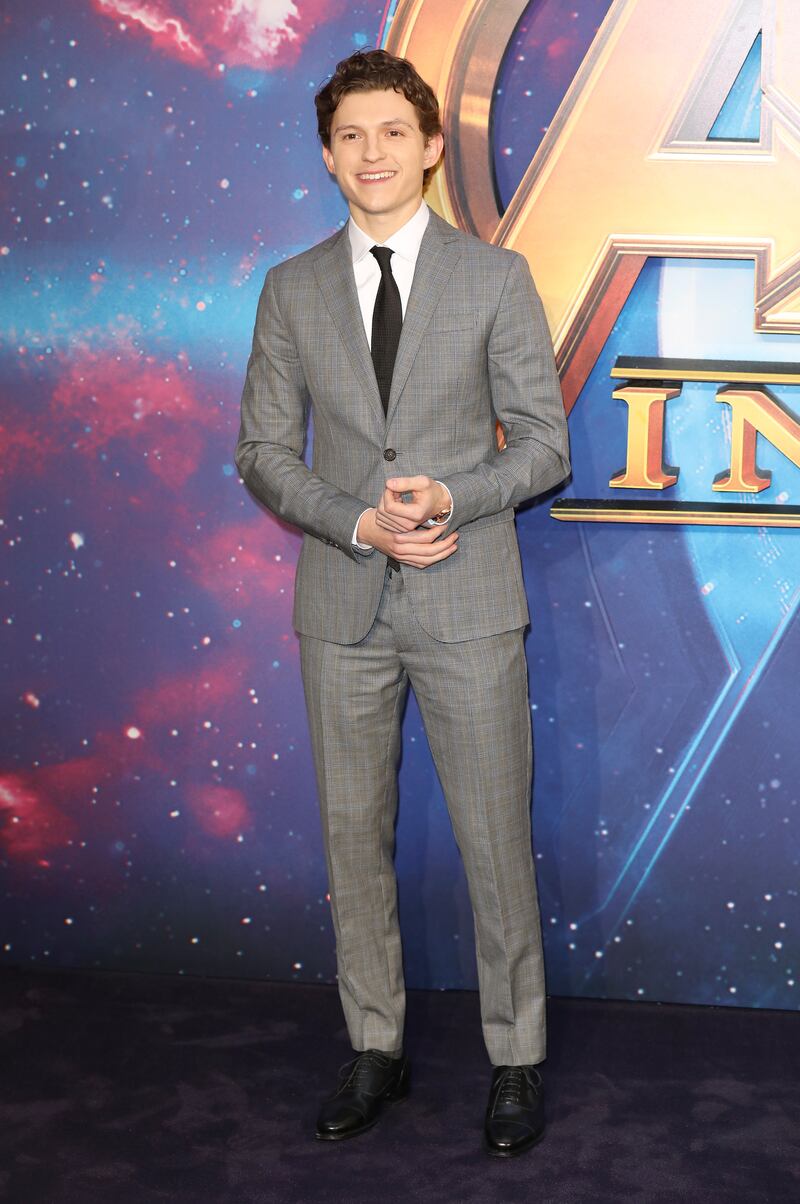 Tom Holland, in a grey suit, attends a UK 'Avengers: Infinity War' fan event in London on April 8, 2018. Getty Images