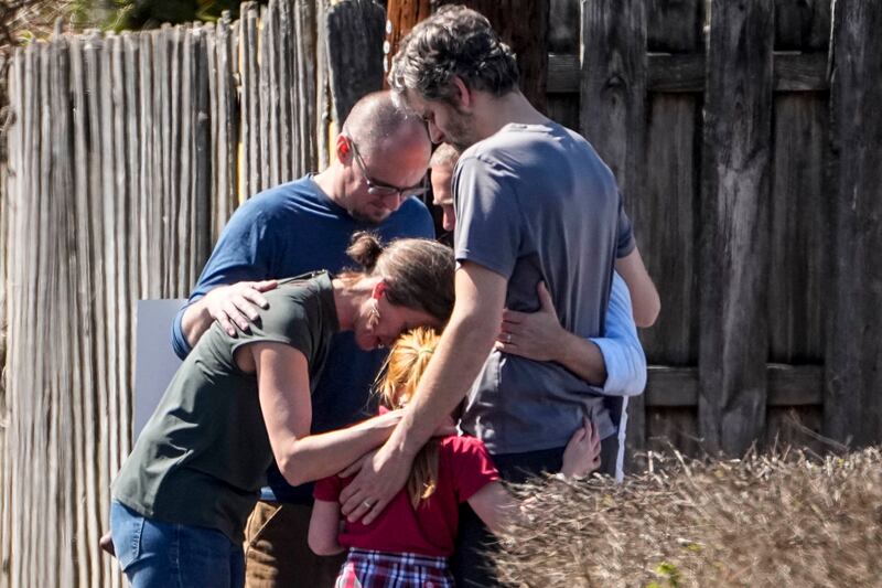 A group prays with a child at the Woodmont Baptist Church after the shooting. AP