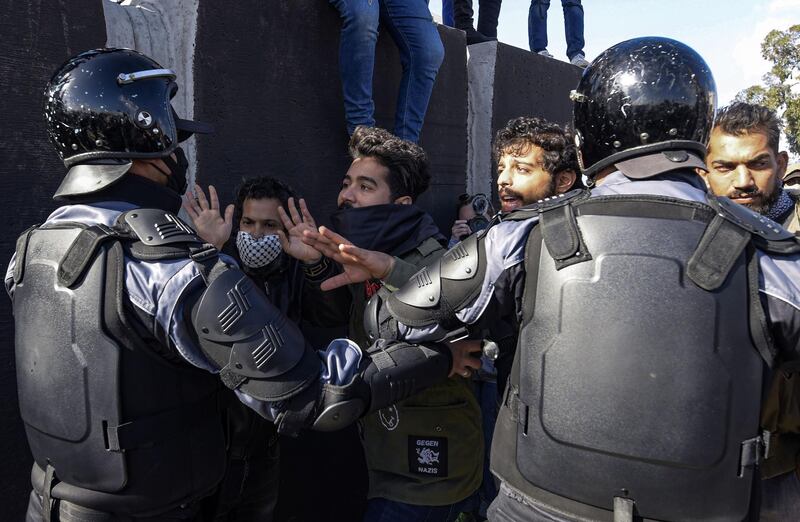 Security forces confront protesters from the Ettadhamen city suburb on the northwestwern outskirts of Tunisia's capital Tunis as they prevent them from passage onwards to reach an anti-government demonstration outside the Tunisian Assembly headquarters.  AFP