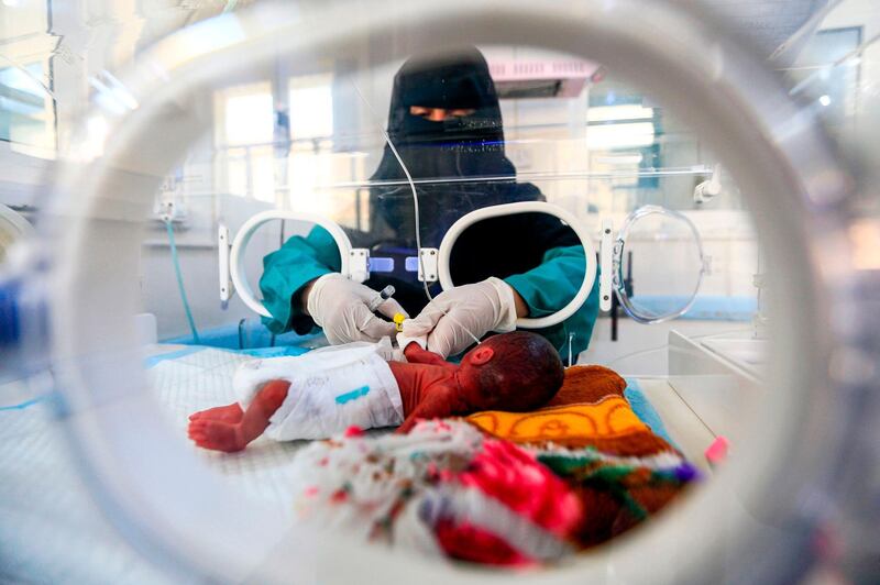 A Yemeni healthcare worker injects a syringe into the intravenous line of an premature-born infant, at the neonatal intensive care unit (NICU) of Al Sabeen Maternal Hospital in Sanaa.  AFP