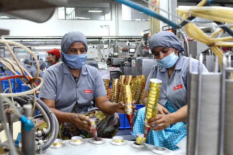 Factory workers place ice cream cones on the production line at the Havmor Ice Cream plant at Naroda near Ahmedabad. While these frozen treats are hugely popular in India especially during summer, the hours-long power cuts during during this period make it difficult for ice cream makers to sell their products in rural areas. Sam Panthaky / AFP