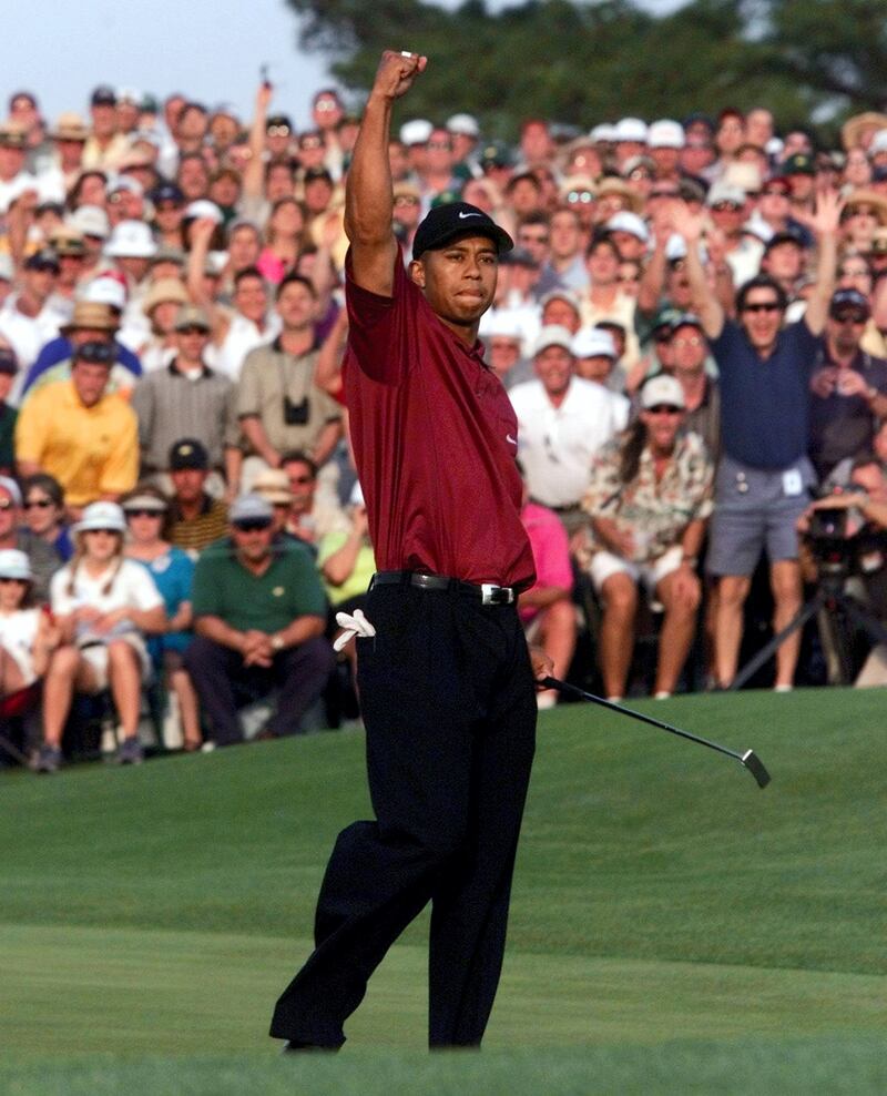Tiger Woods of the US reacts to making the final, winning  putt on the 18th hole 08 April 2001 in the final round of the 2001 Masters Golf Tournament at the Augusta National Golf Club in Augusta, Georgia. Woods held his nerve in one of the most thrilling final days in Masters history  to become the first player ever to hold all four Major titles at the same time.  AFP PHOTO/Timothy A. CLARY (Photo by TIMOTHY A. CLARY / AFP)