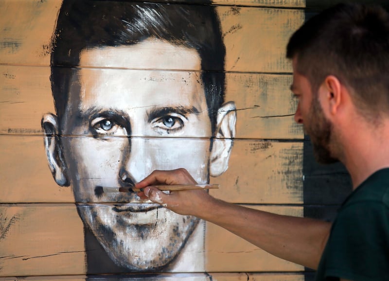 Marko Janjic, an artist, draws a portrait of Serbian tennis player Novak Djokovic on a house in Vodice, Serbia, June 25, 2020. Djokovic tested positive for the coronavirus after taking part in a tennis exhibition series he organised in Serbia and Croatia. Darko Vojinovic / AP