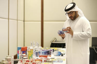 Captain Ahmed Al Kaabi from Abu Dhabi Police views counterfeit products on show during a workshop held by The Legal Group in Abu Dhabi. Pawan Singh / The National 