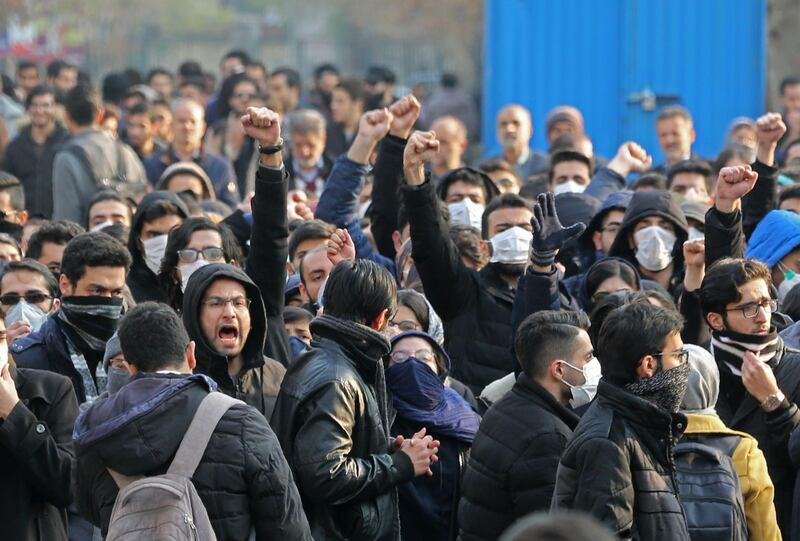 Iranian students gather for a demonstration over the downing of a Ukrainian airliner at Tehran University on January 14, 2020. AFP correspondents said around 200 mainly masked students gathered at Tehran University and were locked in a tense standoff with youths from the Basij militia loyal to the establishment."Death to Britain," women clad in black chadours chanted as Basij members burned a cardboard cutout of the British ambassador to Tehran, Rob Macaire, after his brief arrest for allegedly attending a demonstration Saturday. Kept apart by security forces, the groups eventually parted ways.
 / AFP / ATTA KENARE
