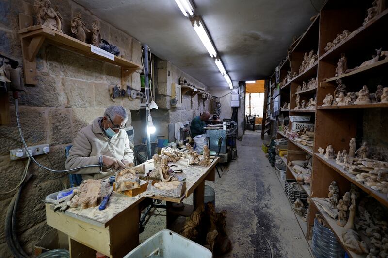 A Palestinian makes olive wood souvenirs near the Church of Nativity in Bethlehem. Reuters 