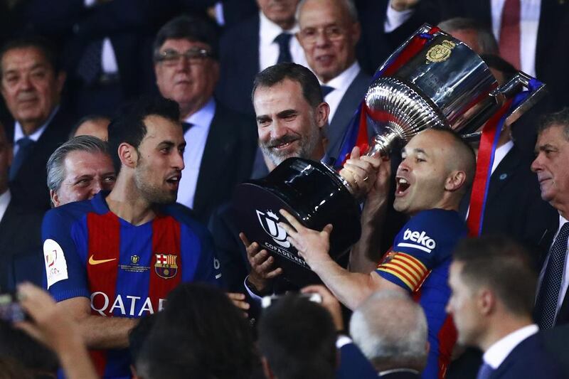 King Felipe VI of Spain, second right, hands the Copa del Rey to Barcelona captain Andres Iniesta, right. Gonzalo Arroyo Moreno / Getty Images