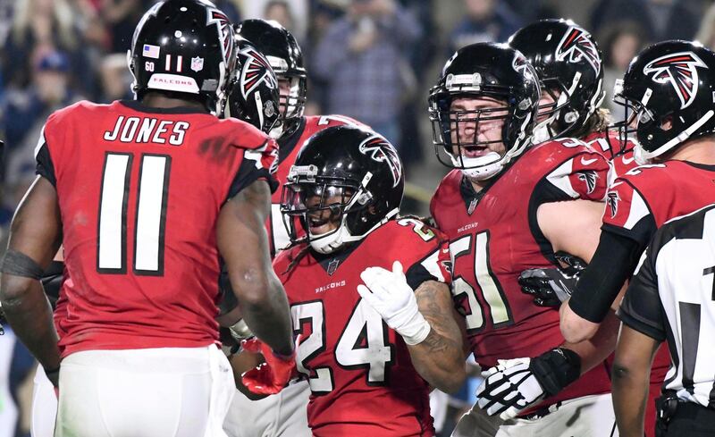 Jan 6, 2018; Los Angeles, CA, USA; Atlanta Falcons running back Devonta Freeman (24) celebrates with offensive tackle Jake Matthews (70) and center Alex Mack (51) after scoring a touchdown in the second quarter against the Los Angeles Rams in the NFC Wild Card playoff football game at Los Angeles Memorial Coliseum. Mandatory Credit: Robert Hanashiro-USA TODAY Sports