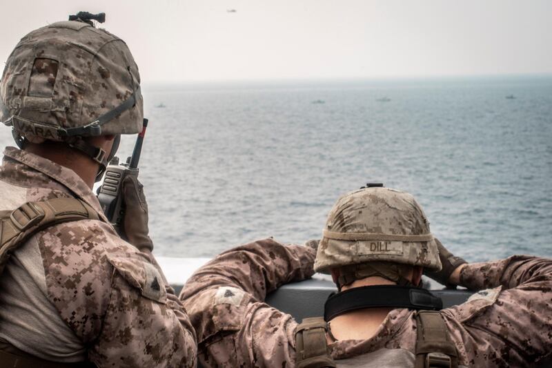 Marines onboard the amphibious transport dock ship USS John P. Murtha (LPD 26) watch nearby Iranian fast inland attack craft, as it transits the Strait of Hormuz, off Oman, in this undated handout picture released by U.S. Navy on August 12, 2019. Adam Dublinske/U.S. Navy/Handout via REUTERS ATTENTION EDITORS- THIS IMAGE HAS BEEN SUPPLIED BY A THIRD PARTY.