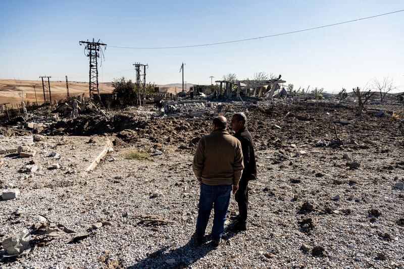 People look at a site damaged by Turkish air strikes in Taql Baql, Hasakah province. AP