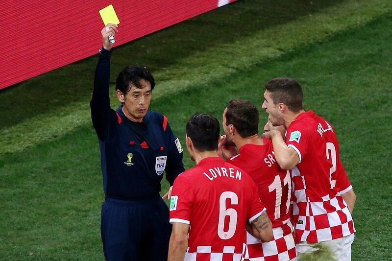 Japanese referee Yuichi Nishimura shows Dejan Lovren a yellow card, awarding Brazil a penalty in their win over Croatia on Thursday night. Elsa / Getty Images / June 12, 2014