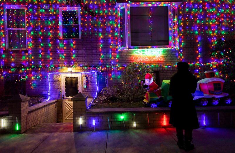 People look at a house decorated in Christmas lights in the Dyker Heights neighborhood of Brooklyn, New York, USA. Dyker Heights is know for its elaborate Christmas light displays.  EPA
